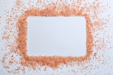 Photo of Frame of pink himalayan salt on white background, top view. Space for text