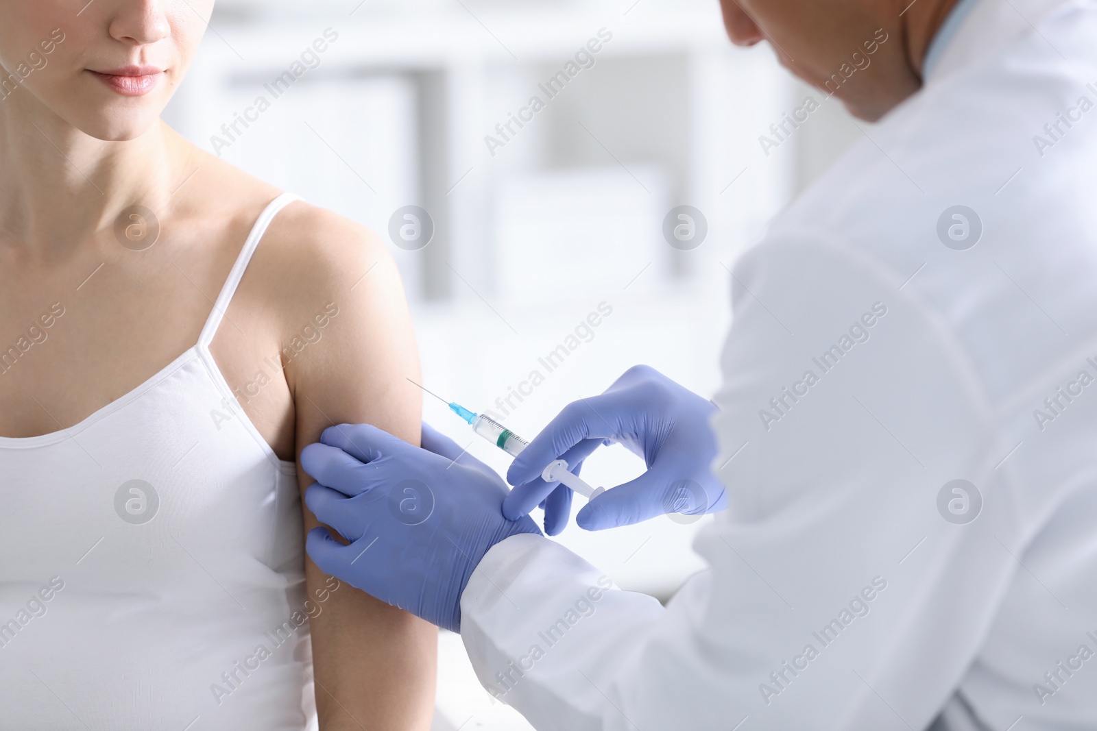 Photo of Doctor giving injection to pregnant woman in hospital, closeup. Vaccination concept