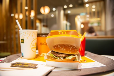 Photo of WARSAW, POLAND - SEPTEMBER 04, 2022: McDonald's French fries, burger and drinks on table indoors