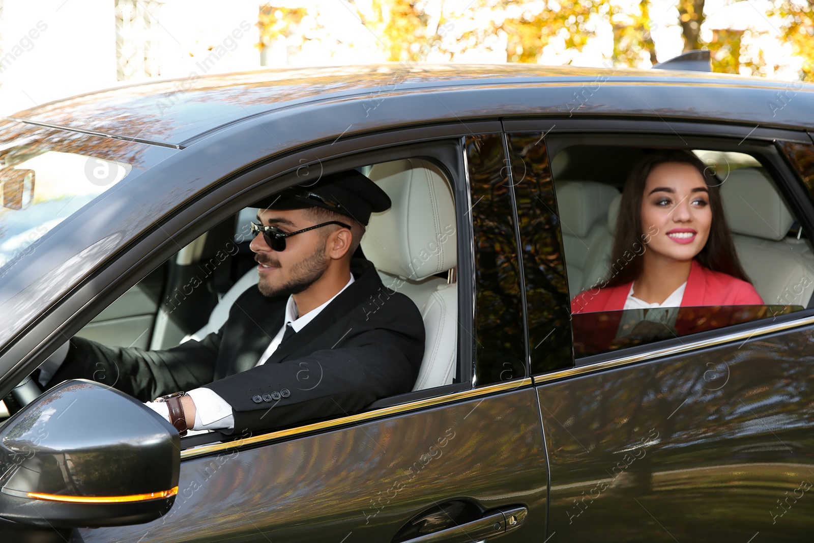 Photo of Young businesswoman with handsome driver in luxury car