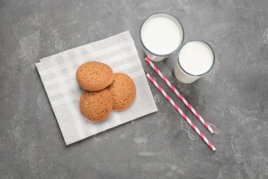 Photo of Glasses of milk and oatmeal cookies on table. Fresh dairy product