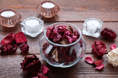 Photo of Aromatic potpourri of dried flowers in glass jar on wooden table