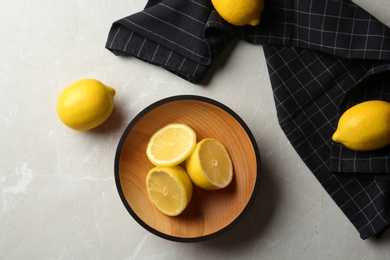 Flat lay composition with lemons and fabric on light background