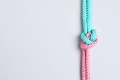 Colorful ropes tied together with knot isolated on white, top view. Unity concept