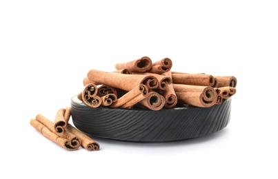 Photo of Bowl with aromatic cinnamon sticks on white background