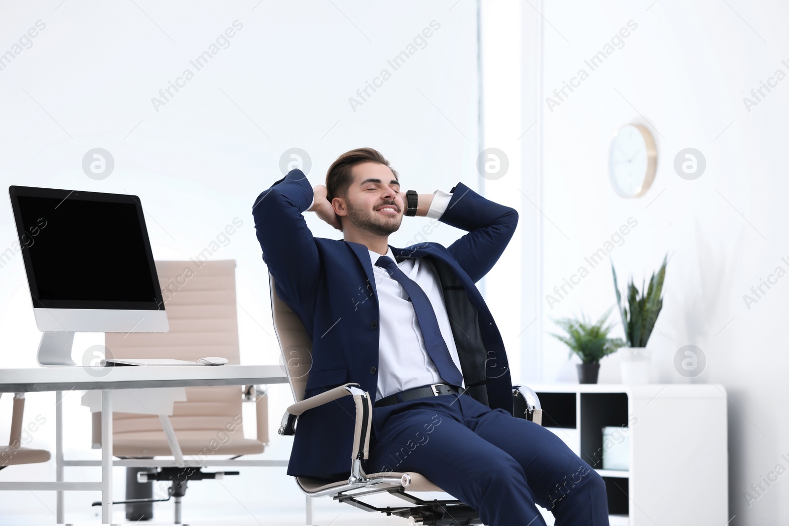 Photo of Young businessman sitting on office chair at workplace
