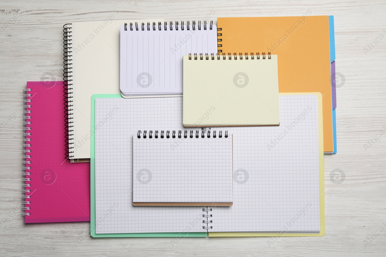 Photo of Many different notebooks on white wooden table, flat lay