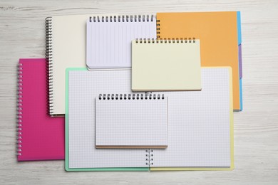 Photo of Many different notebooks on white wooden table, flat lay