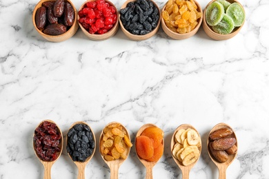 Flat lay composition with different dried fruits on marble background, space for text. Healthy lifestyle