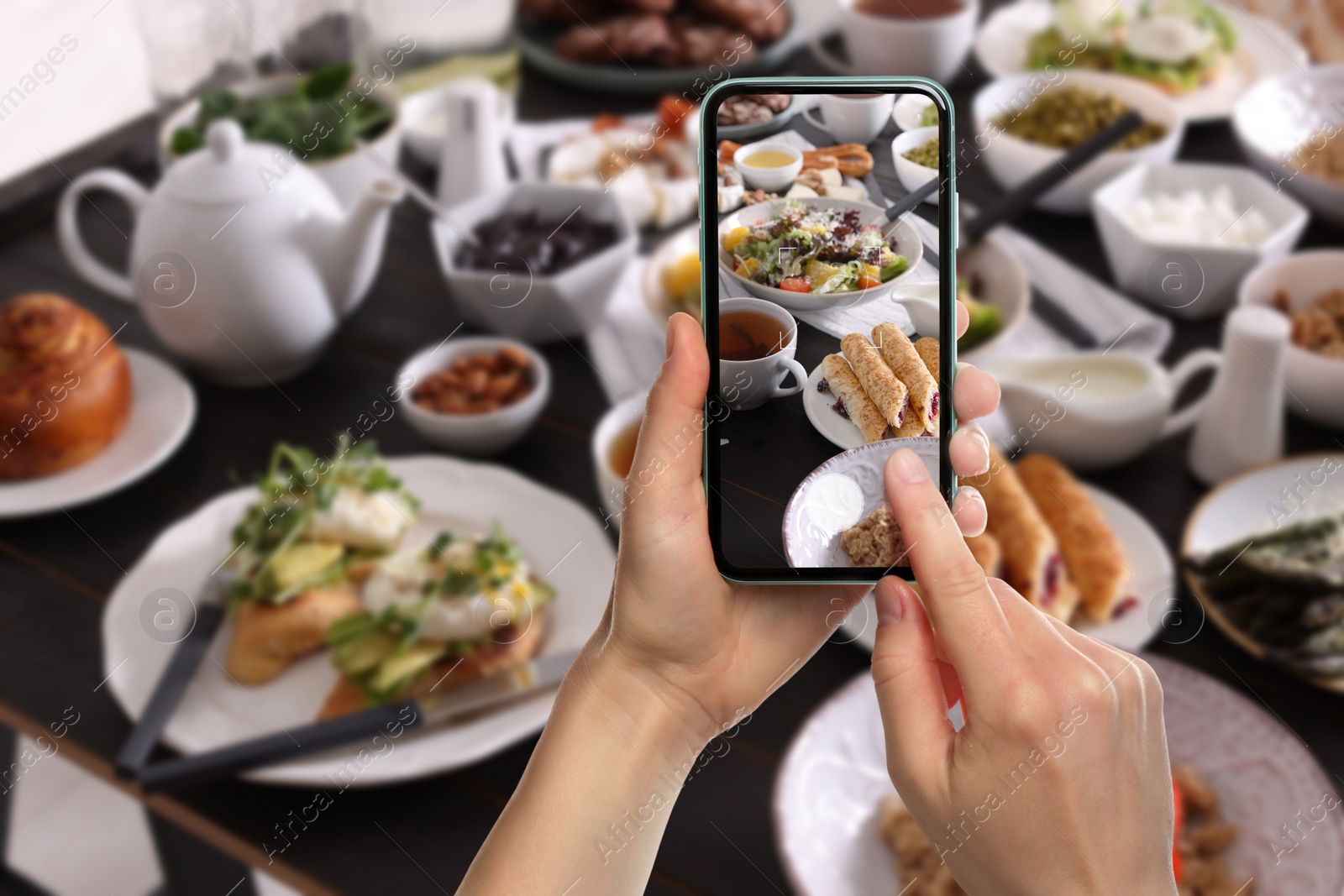 Image of Woman taking picture of different dishes served on wooden table, closeup