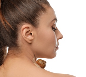 Beautiful young woman with snail on her neck against white background