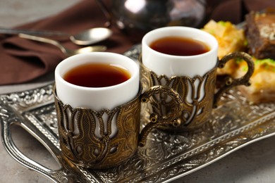 Photo of Tea served in vintage tea set on grey table, closeup