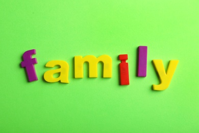Photo of Word FAMILY of magnetic letters on color background, top view
