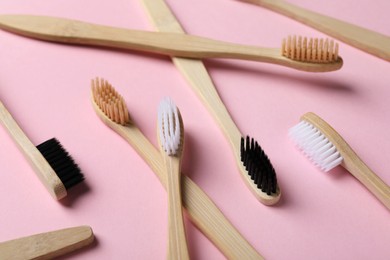 Photo of Many bamboo toothbrushes on pink background, closeup