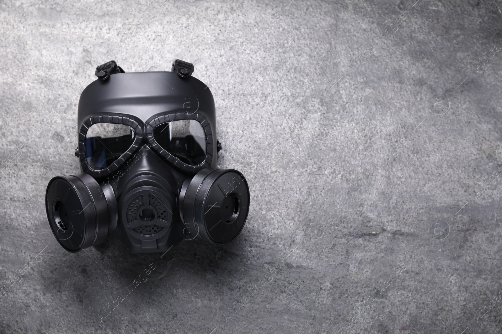 Photo of One gas mask on grey textured background, top view. Space for text