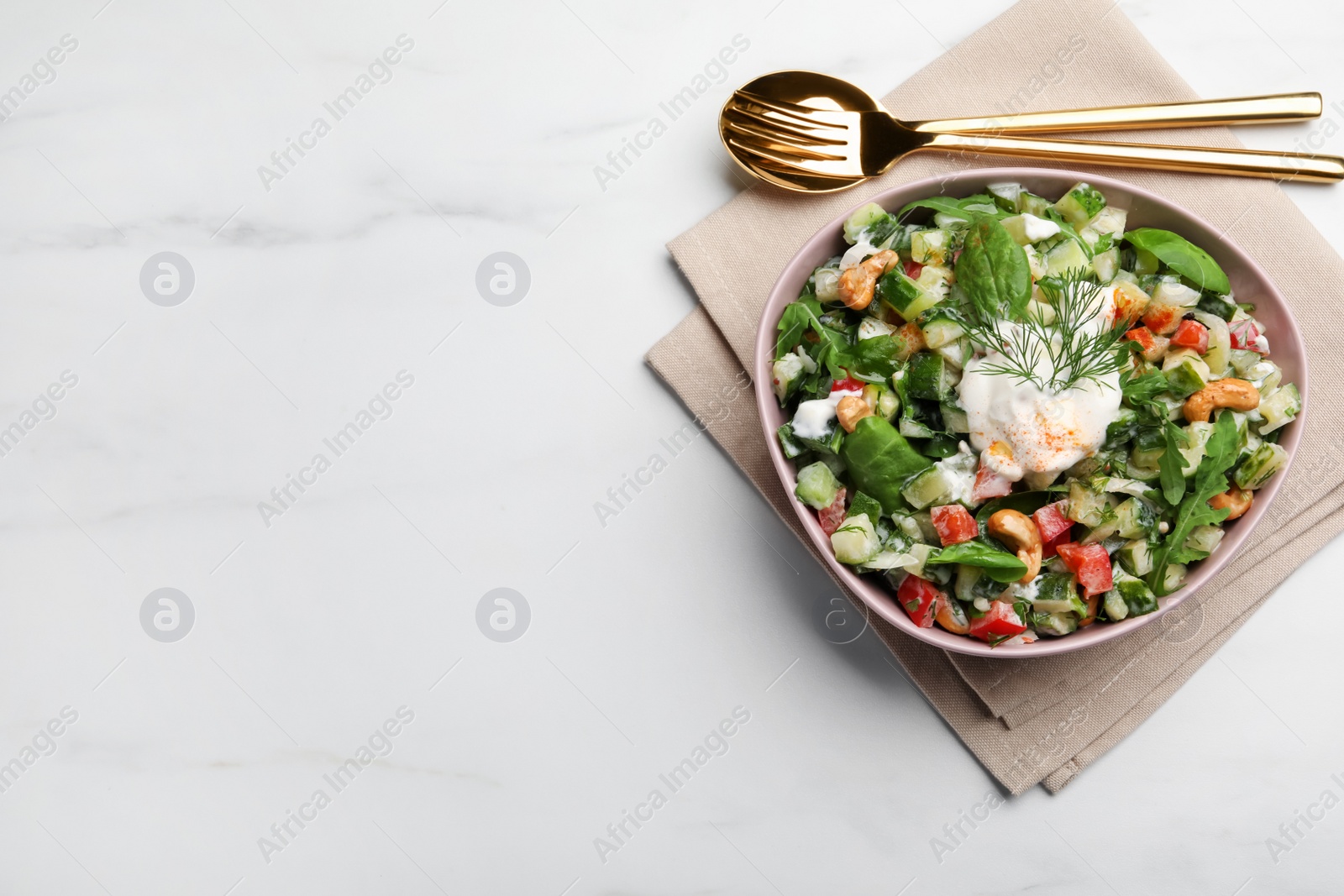 Photo of Bowl of delicious cucumber salad served on white marble table, flat lay. Space for text