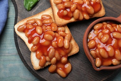 Photo of Toasts with delicious canned beans on light blue wooden table, top view