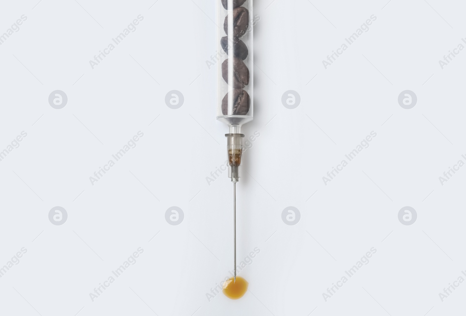 Photo of Syringe full of coffee beans on white background, top view. Caffeine addiction concept