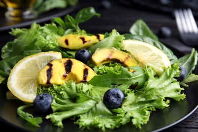 Delicious avocado salad with lemon and blueberries on table, closeup