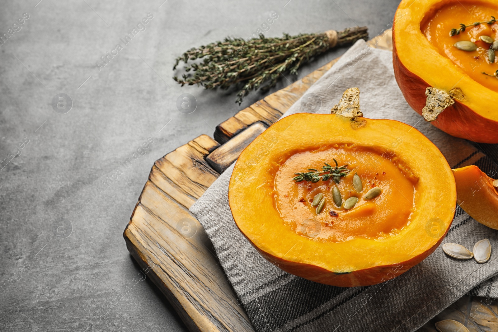 Photo of Tasty cream soup served in pumpkin on table. Space for text