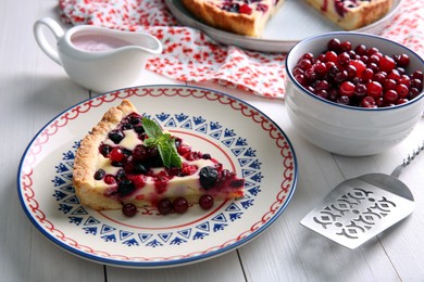 Photo of Piece of delicious currant pie served on white wooden table