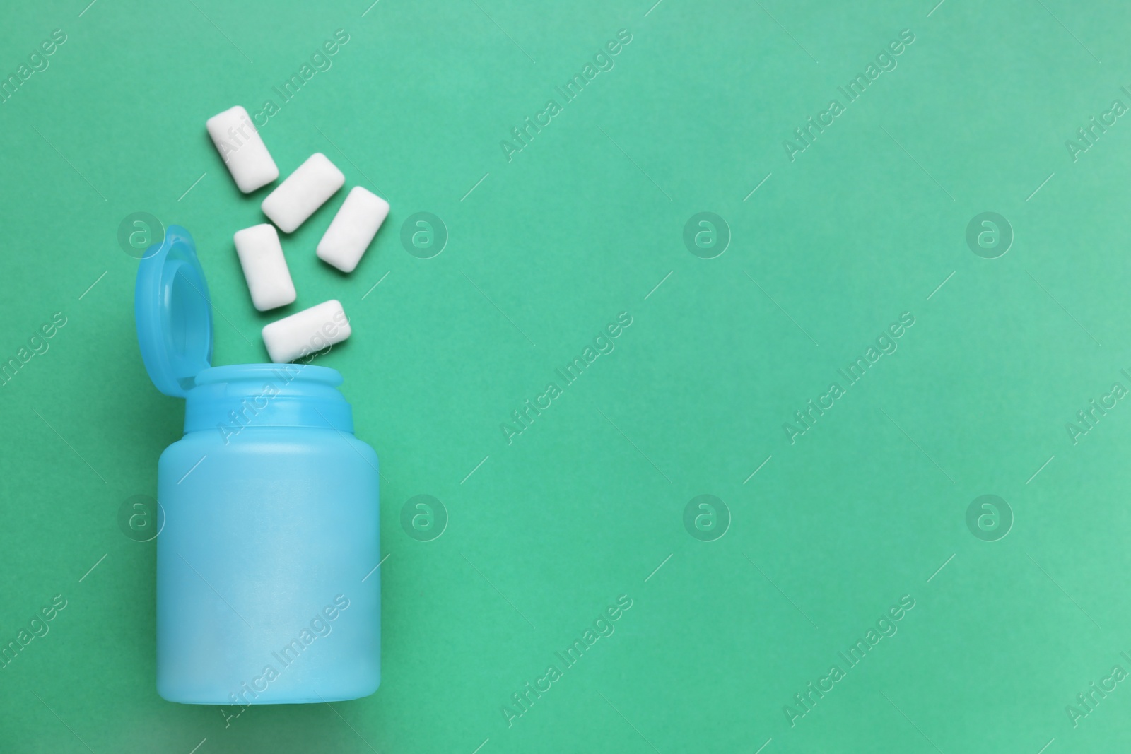 Photo of Jar with chewing gums on green background, flat lay. Space for text