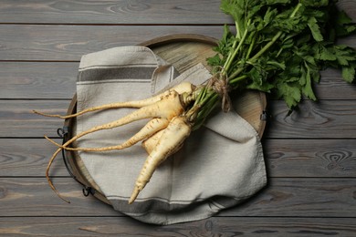 Photo of Tasty fresh ripe parsnips on grey wooden table, top view