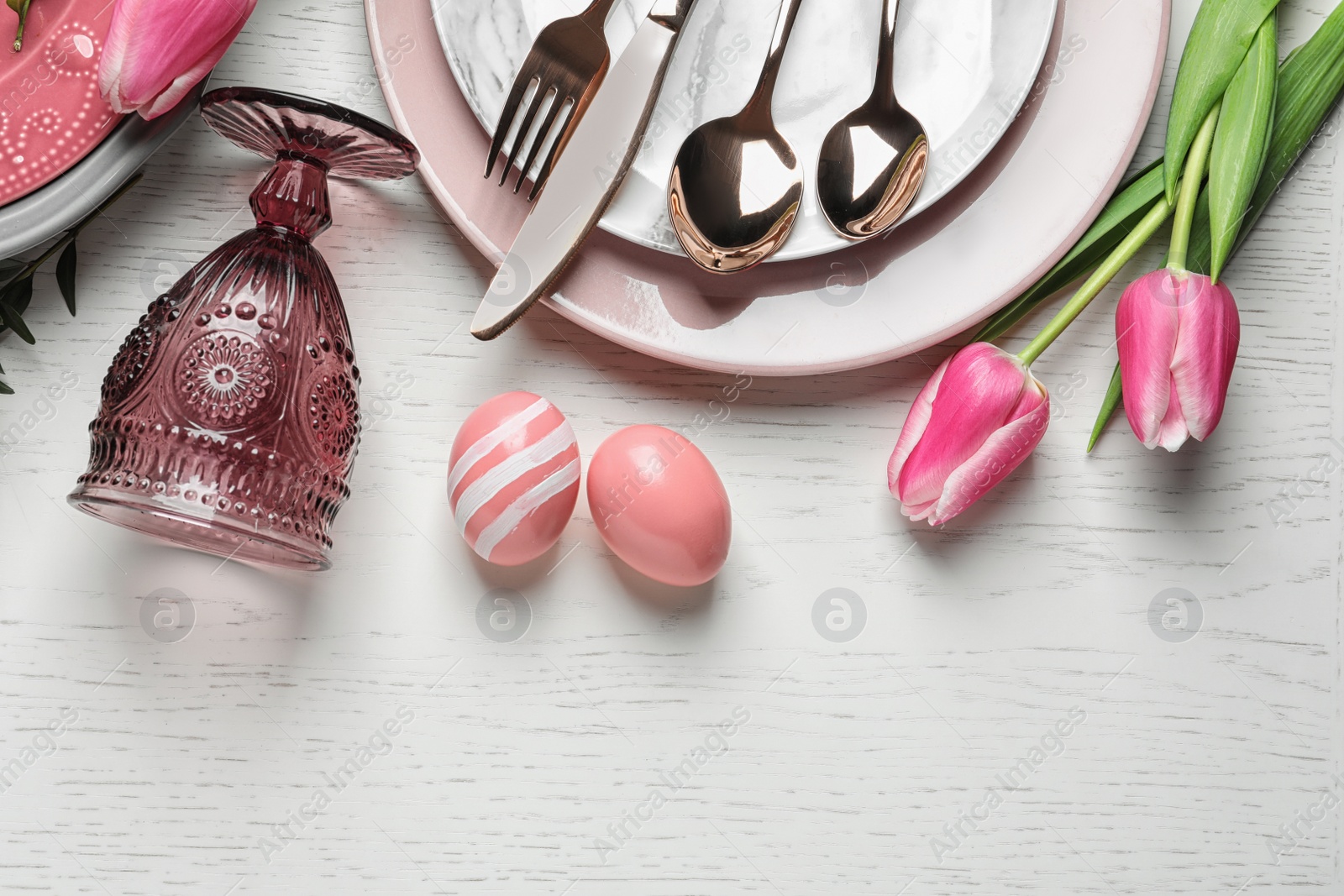 Photo of Festive Easter table setting with eggs on wooden background, top view