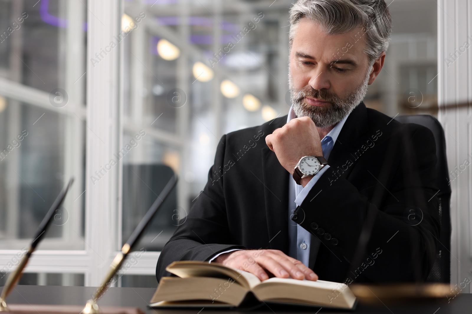 Photo of Portrait of confident lawyer at table in office