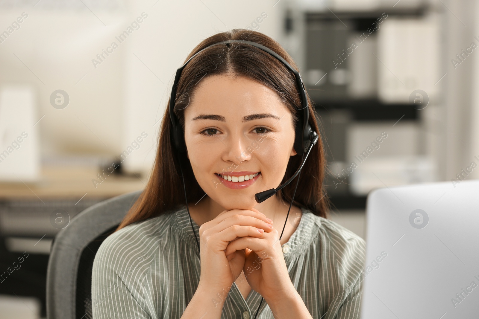 Photo of Hotline operator with headset working in office