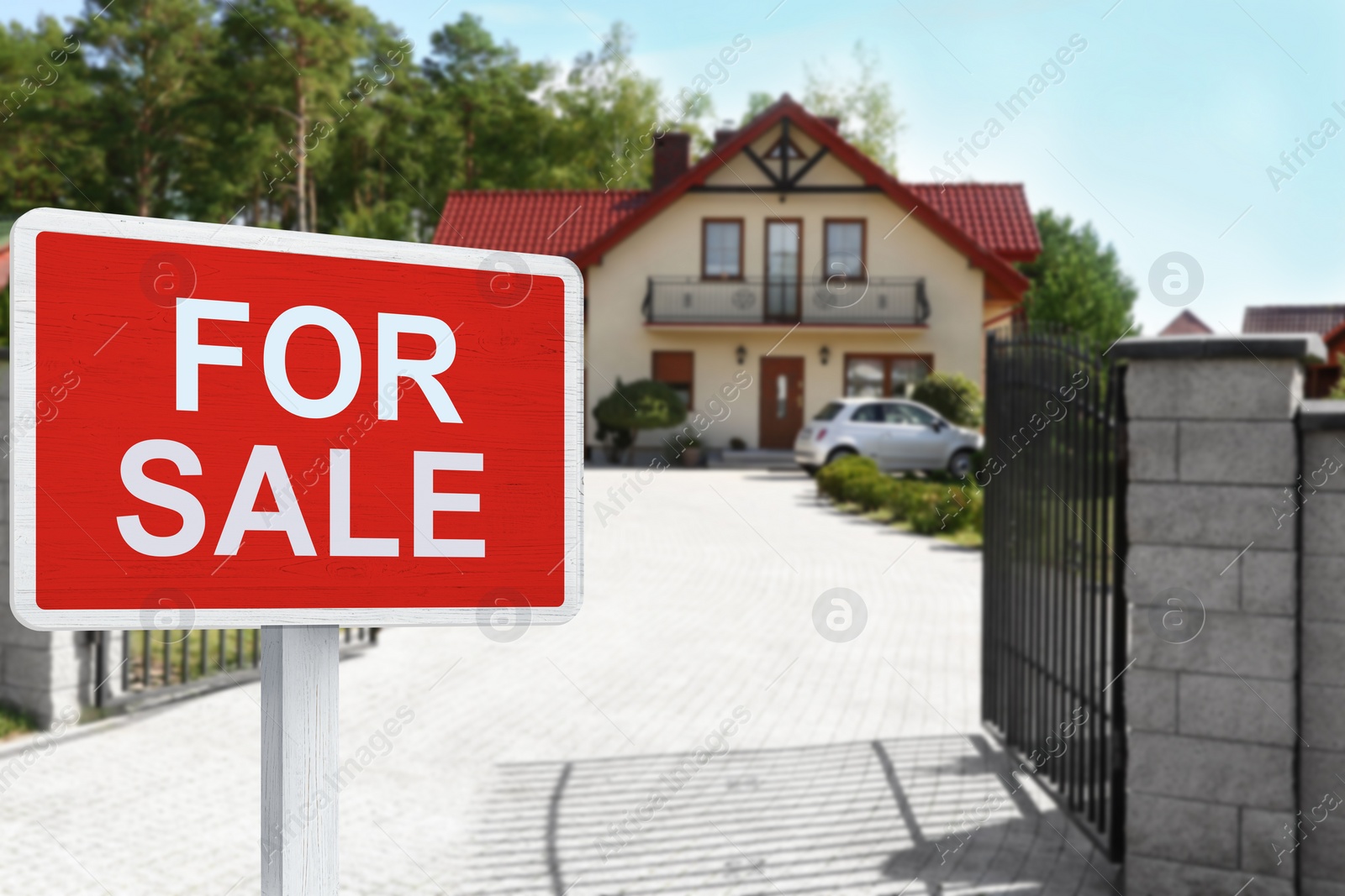 Image of Sale sign near beautiful house outdoors. Red signboard with words