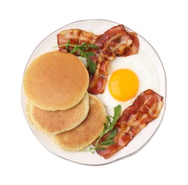 Plate with tasty pancakes, fried egg, arugula and bacon isolated on white, top view