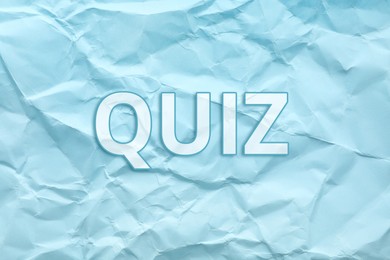 Phrase QUIZ on crumpled light blue paper 