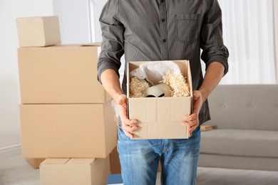 Man with moving box in his new house, closeup view