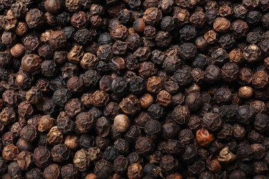 Aromatic spice. Black peppercorns as background, top view