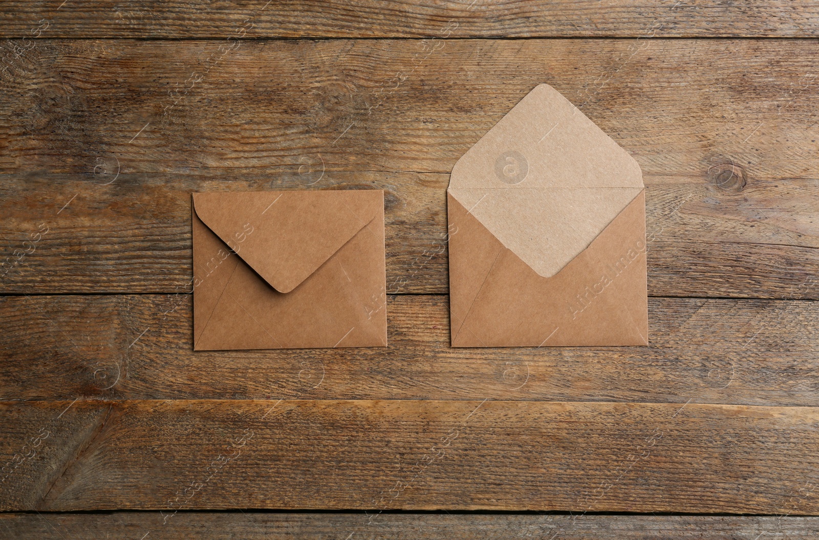 Photo of Brown paper envelopes on wooden background, flat lay