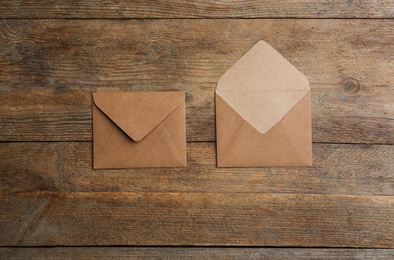 Photo of Brown paper envelopes on wooden background, flat lay