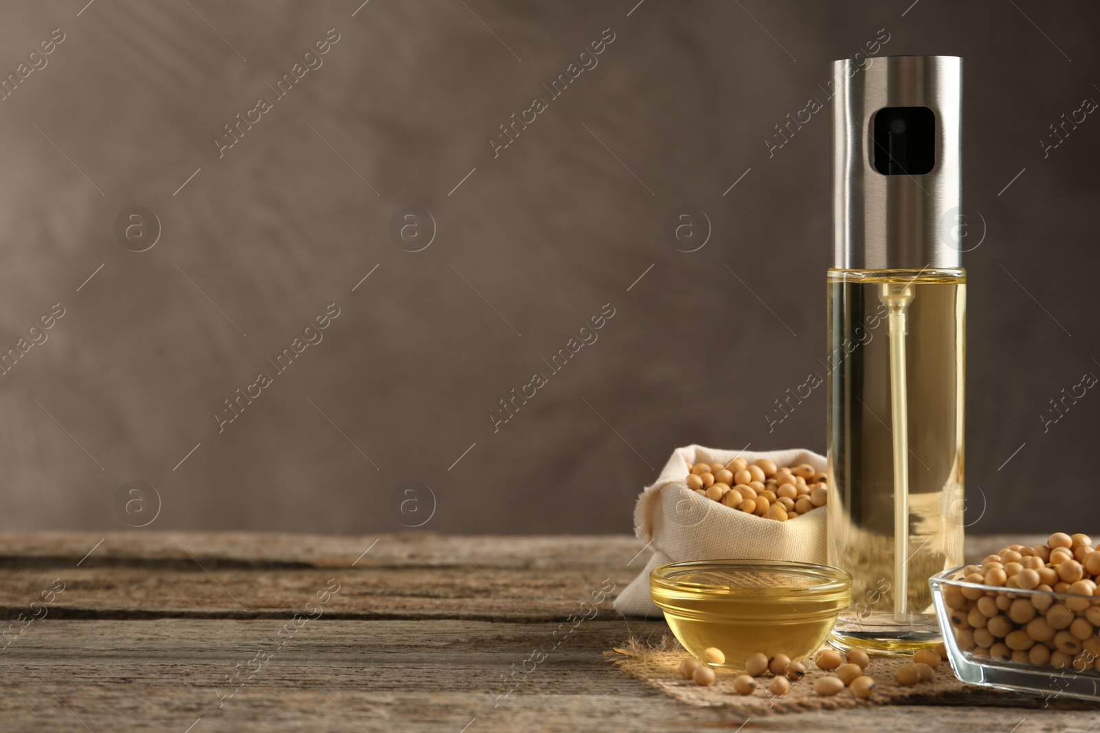 Photo of Composition with soybean oil on wooden table. Space for text