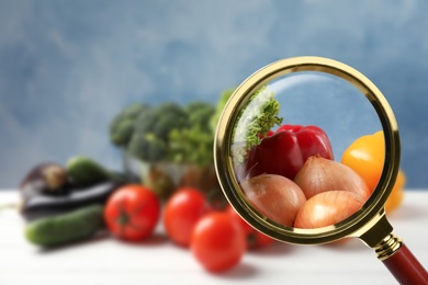 View through magnifying glass on vegetables, closeup. Poison detection