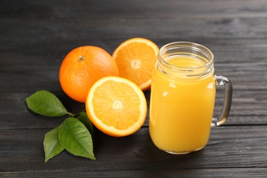 Delicious orange juice and fresh fruits on black wooden table