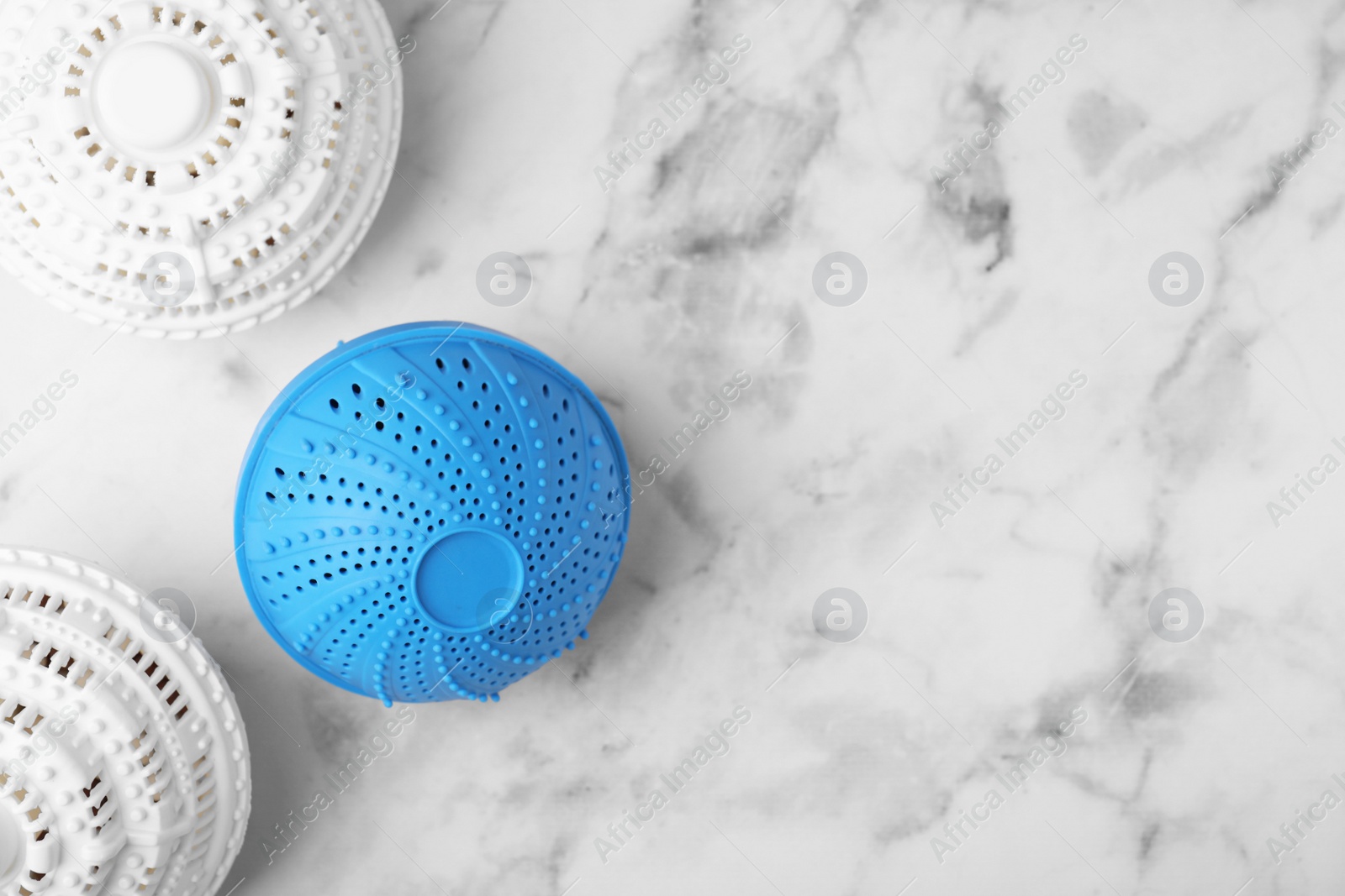 Photo of Laundry dryer balls on white marble table, flat lay. Space for text