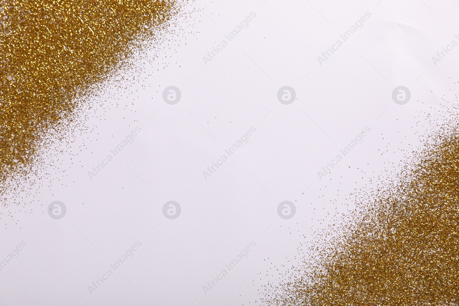 Photo of Shiny golden glitter on white background, top view