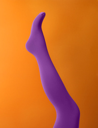 Photo of Leg mannequin in purple tights on orange background