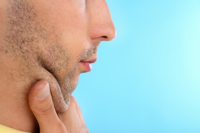 Young man with double chin on blue background, closeup. Space for text