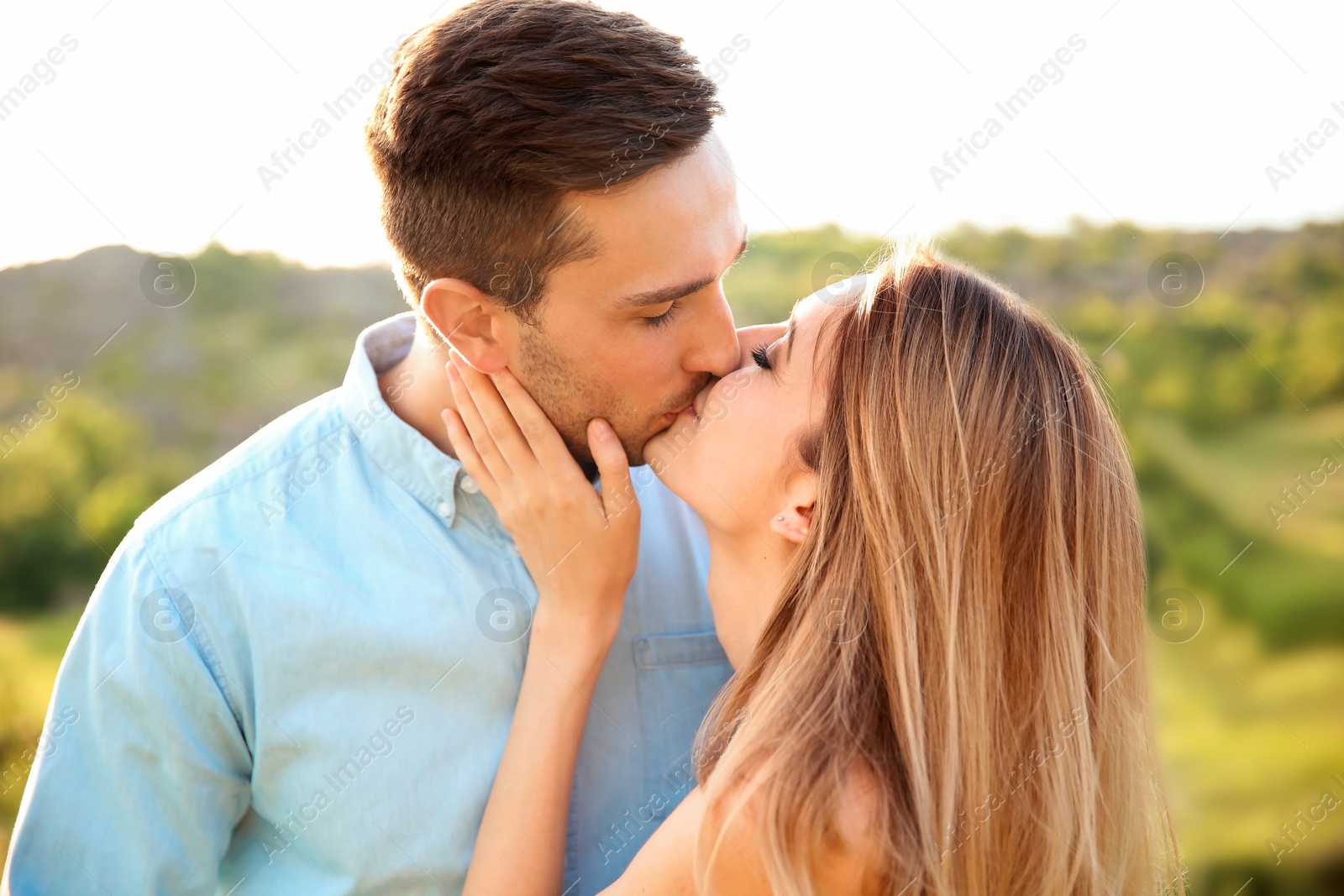 Photo of Cute young couple in love posing outdoors on sunny day