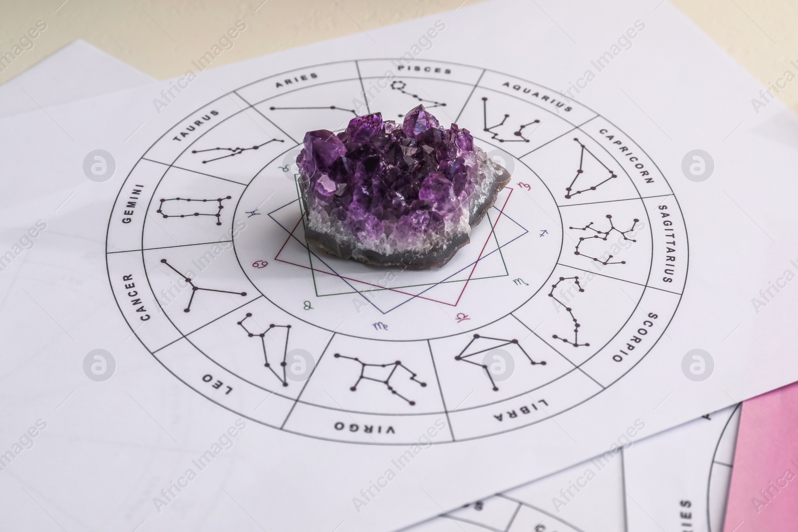 Photo of Zodiac wheel and gemstone for making forecast of fate on table, closeup. Astrological predictions