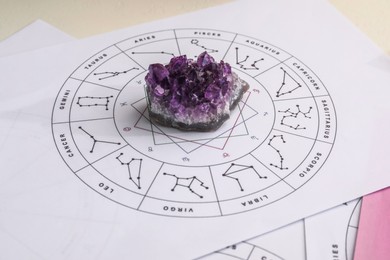 Photo of Zodiac wheel and gemstone for making forecast of fate on table, closeup. Astrological predictions