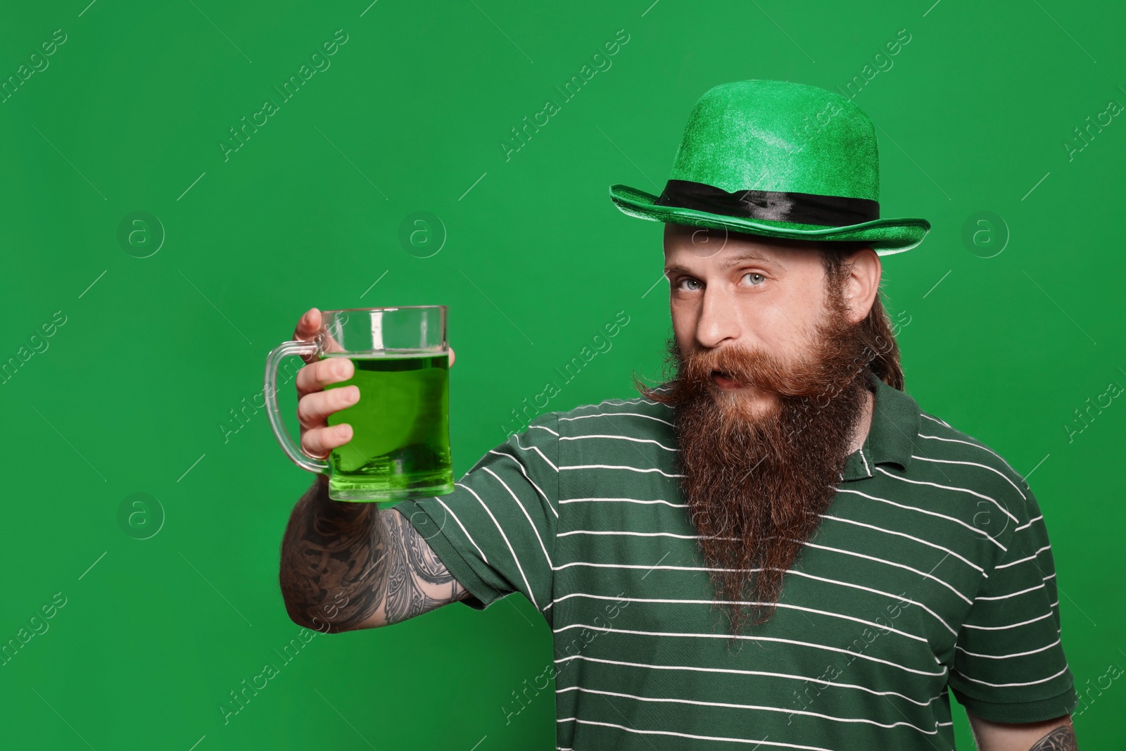 Photo of Bearded man with green beer on color background. St. Patrick's Day celebration