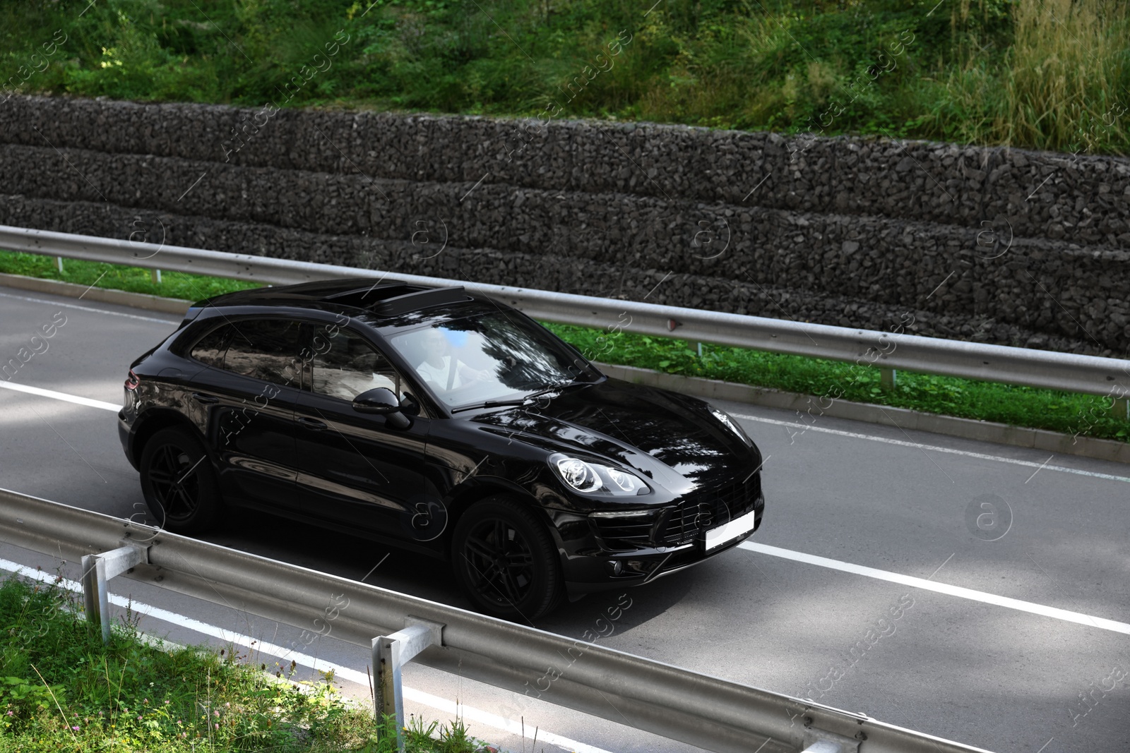 Photo of Picturesque view of asphalt road with modern black car outdoors