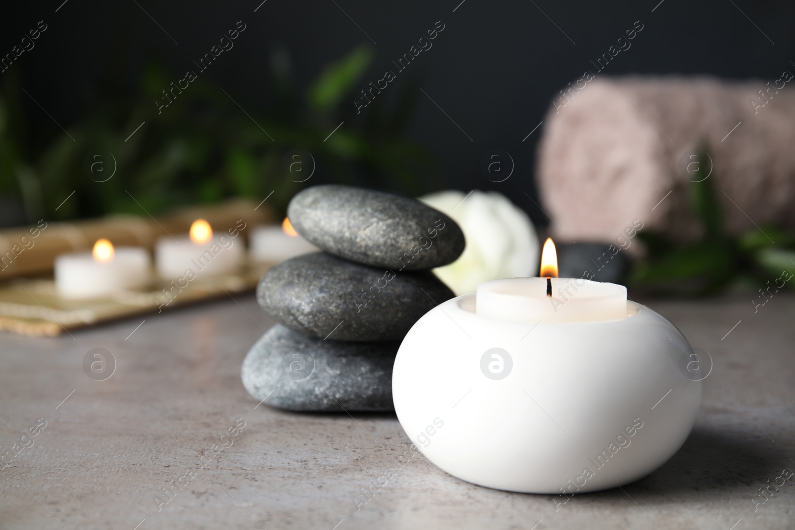 Photo of Spa composition with burning candle on table, space for text